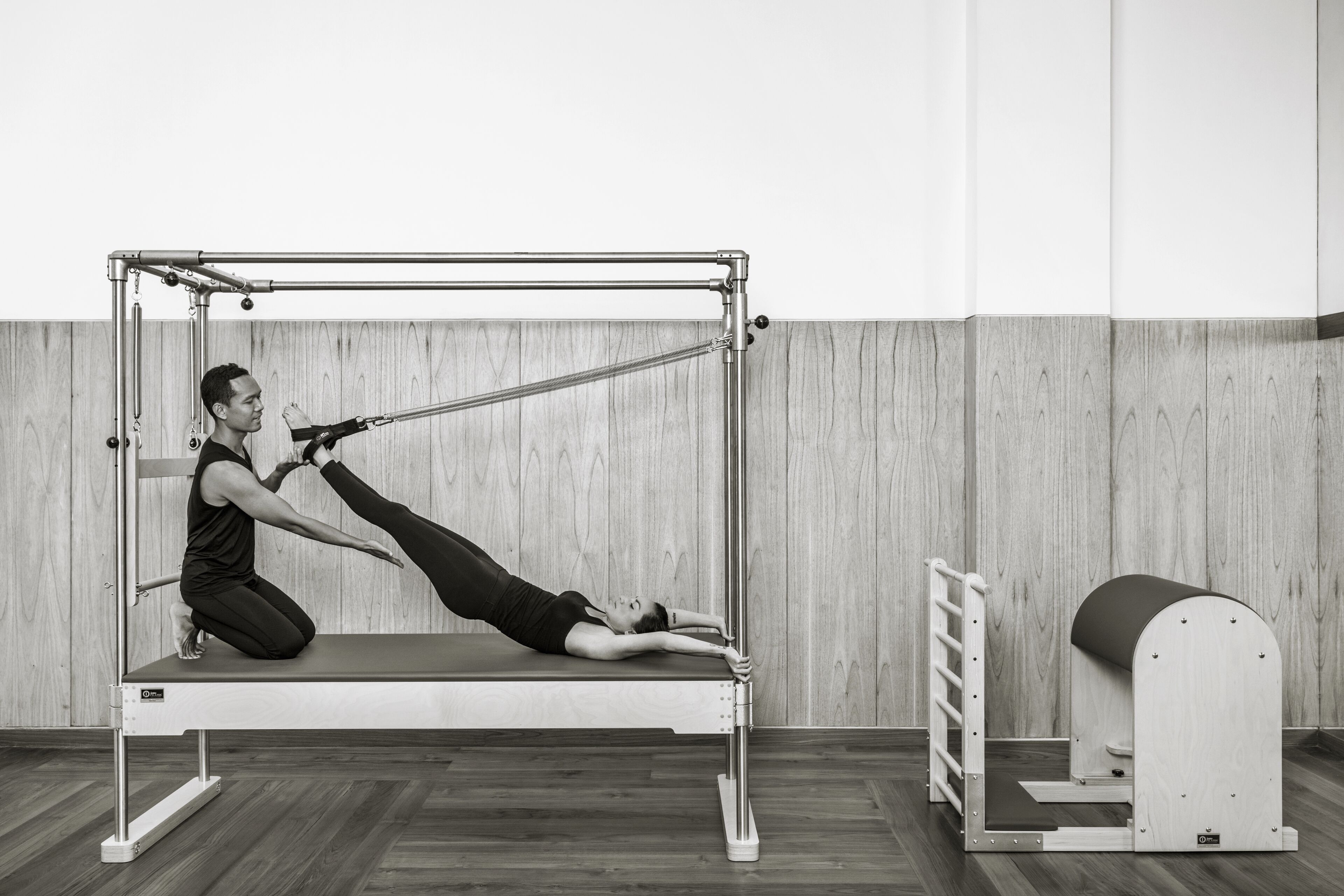 Ein Pilates-Reformer in einem Raum mit Holzwänden und Holzboden.