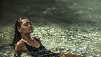 A woman in a swimsuit lying on a clear water surface.
