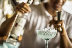 Un bar con una persona sirviendo una bebida en un vaso.