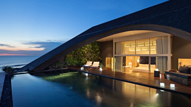 A modern hotel with a pool, lounge chairs, and a view of the ocean. - COMO Uma Canggu (Canggu)