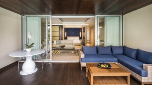 A modern living room with a blue sofa, a white round table, and a wooden coffee table. - COMO Uma Canggu (Canggu)