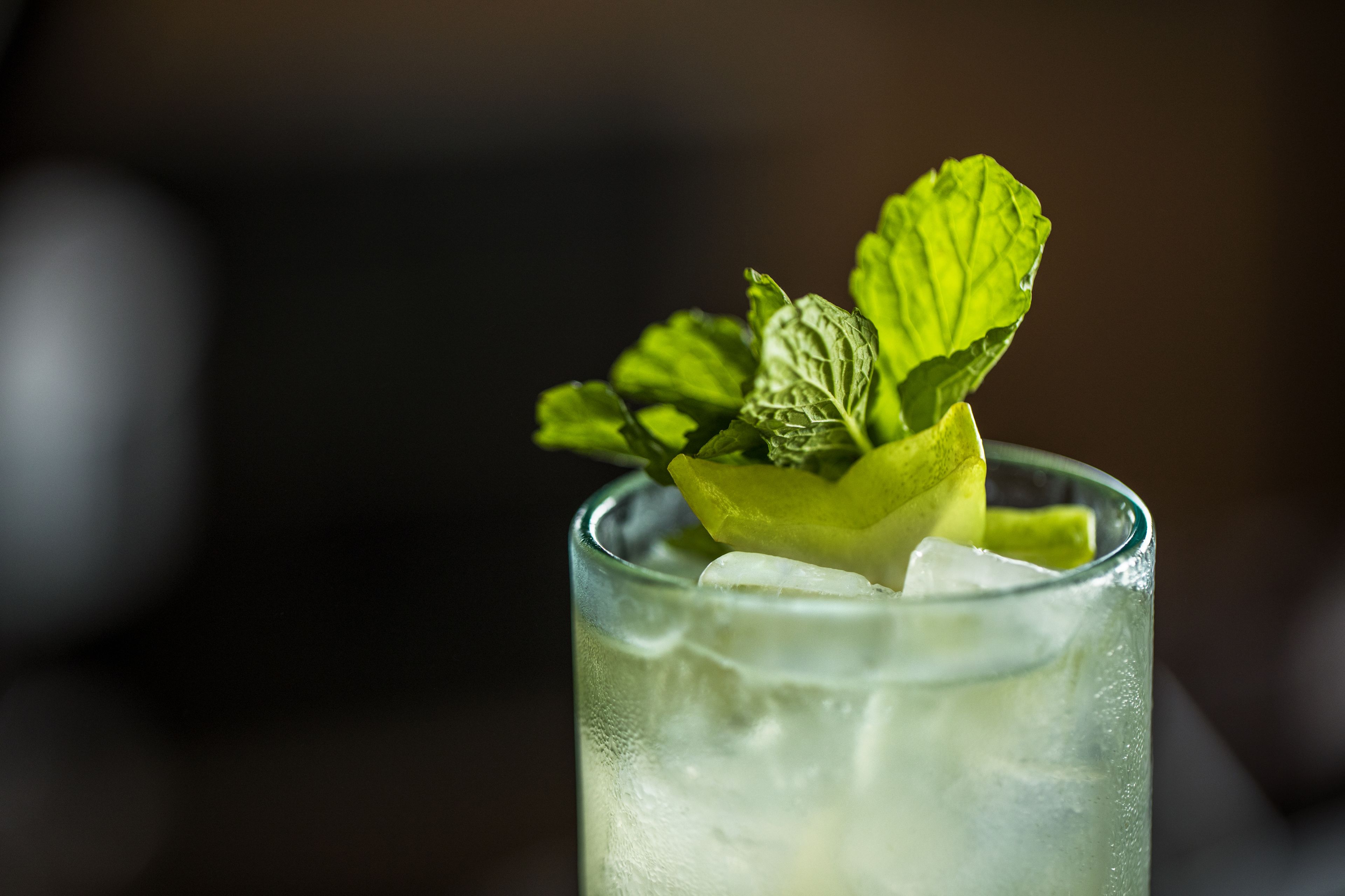 A glass with ice cubes and a lime wedge.