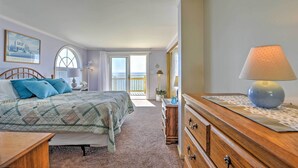 Ein Schlafzimmer mit Bett, Schminktisch, Lampe und Blick ins Freie.