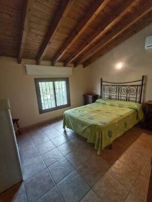 A bedroom with a bed, a window, a nightstand, and a ceiling fan.