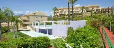 Et resort med pool, frodig beplantning og flere bygninger.