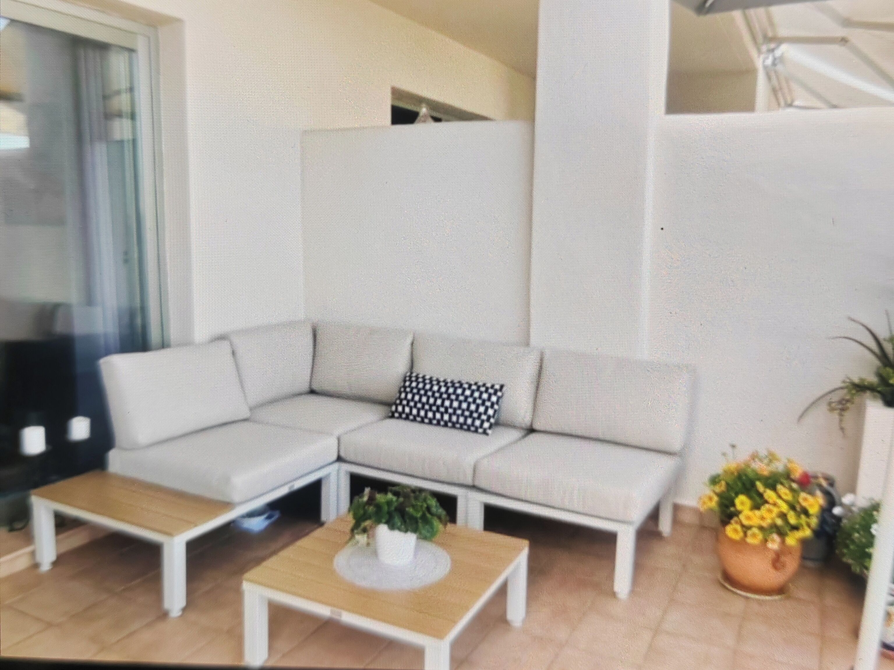 A modern living room with a sectional sofa, two side tables, and a coffee table.