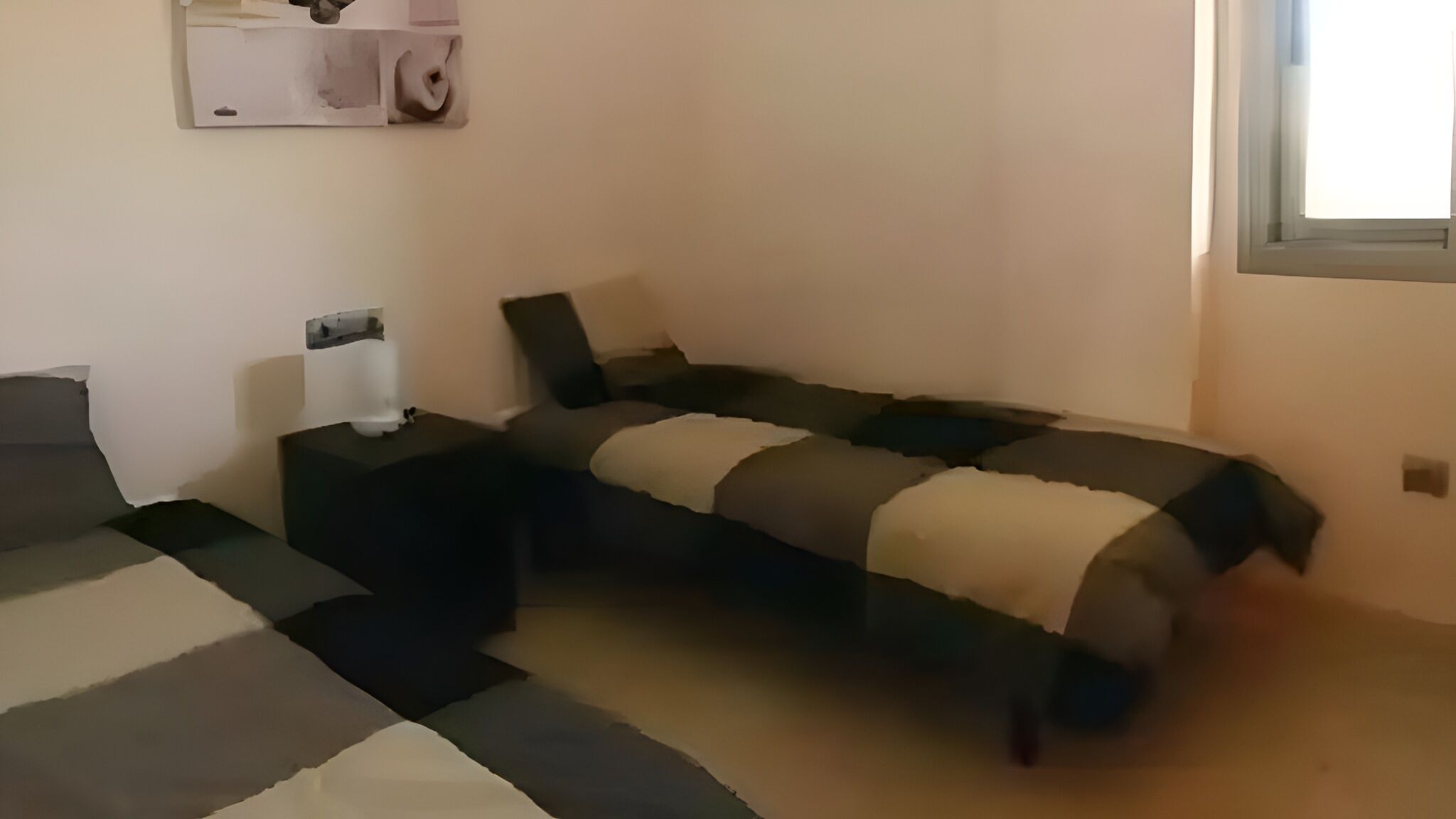 Un dormitorio con cama, mesita de noche y una pequeña mesa.
