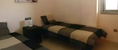 Un dormitorio con cama, mesita de noche y una pequeña mesa.