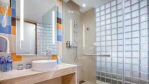A modern bathroom with a white sink, a glass shower enclosure, and a tiled backsplash. - Holiday Inn Express Liuyang Development Zone by IHG (Changsha)