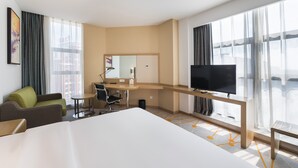A modern hotel room with a large bed, a desk with a chair, a television, and large windows with curtains. - Holiday Inn Express Liuyang Development Zone by IHG (Changsha)