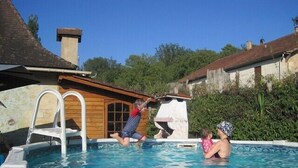 Una piscina con muelle de madera y escalera.