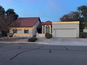 A house with a red-tiled roof, a garage, and decorative lights. - Tempe/Chandler Vacation Home - Community POOL & SPA  (Chandler)