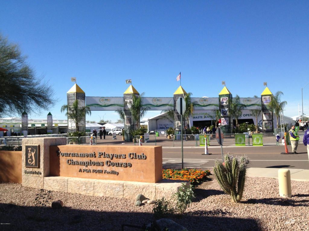 A sign for the Tournament Players Club Champions Course with a clear sky and palm trees in the foreground.
