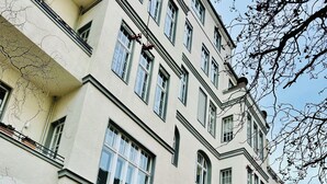 En byggnad med flera våningar i en klassisk arkitektonisk stil, med stora fönster och balkonger.
