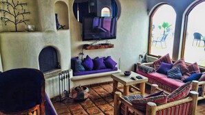 A cozy living room with a sofa, armchairs, and a television.