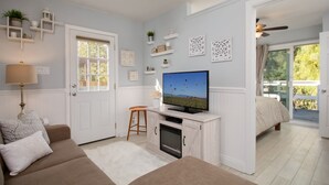 Ein gemütliches Wohnzimmer mit Fernseher, einer Couch, einem Couchtisch und einem Kamin.