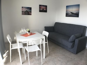 Relax in a serene space with a dining table, coffee table, and comfortable sofa.