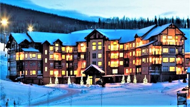 Un gran edificio de varios pisos con muchas ventanas y un paisaje cubierto de nieve.