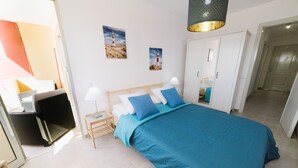 A bedroom with a bed, a nightstand, a wardrobe, and a lamp. - Ocean View apartments. Beachfront Ocean view terrace. Wifi. Parking (Gran Tarajal)