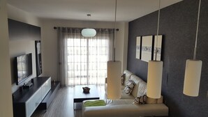 A modern hotel room with a bed, a TV, a desk, and a large window with curtains. - Apartment in El Palm-Mar, Arona, very well decorated, furnished and equipped. (Palm-Mar)