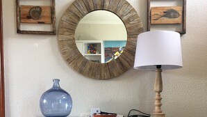 Ein rustikaler Holzkonsolentisch mit Spiegel, einer blauen Vase und einer Lampe.