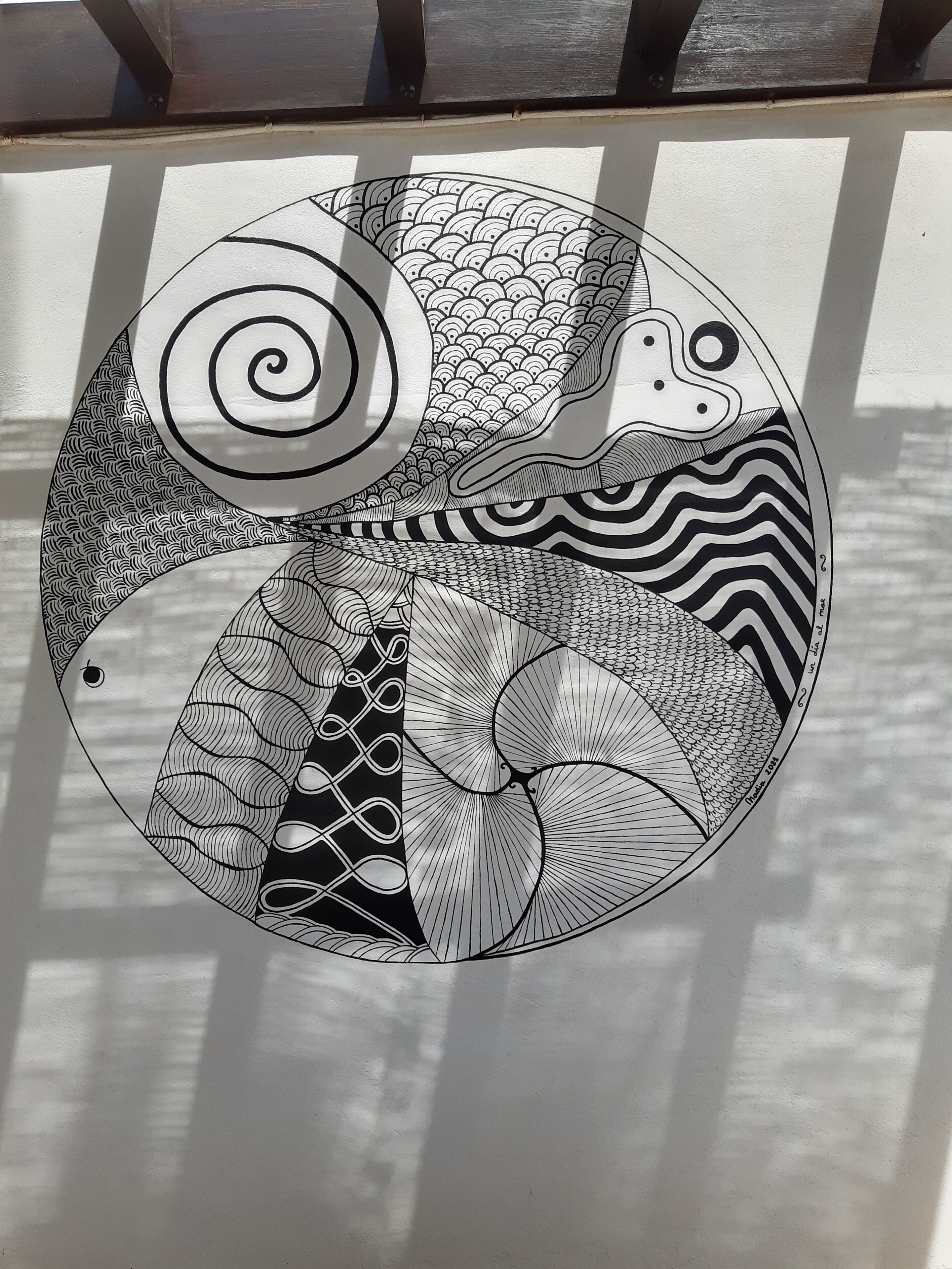 A detailed black and white drawing of a traditional Japanese design on a wall.