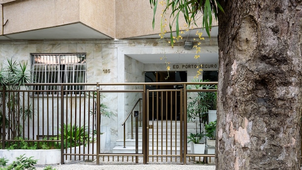 A building entrance with a metal gate, a staircase, and a sign reading "ED. PORTO SECURO". - All in Rio Conforto e Silencio (Rio de Janeiro)