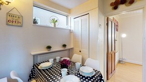 A dining area with a polka dot tablecloth, white chairs, and a sign that says "COME IN WE ARE OPEN". - Orchard in Orpington (St Paul's Cray, Orpington) (Orpington)