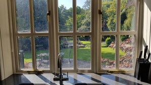 A kitchen with a large window, a sink, and a knife block.