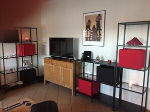 A living room with a TV, wooden cabinet, glass shelves, and a framed picture on the wall. - ALVOR - Portimao, Apartment 6/8 pers. (With large swimming pool) Close to beaches. (Alvor)