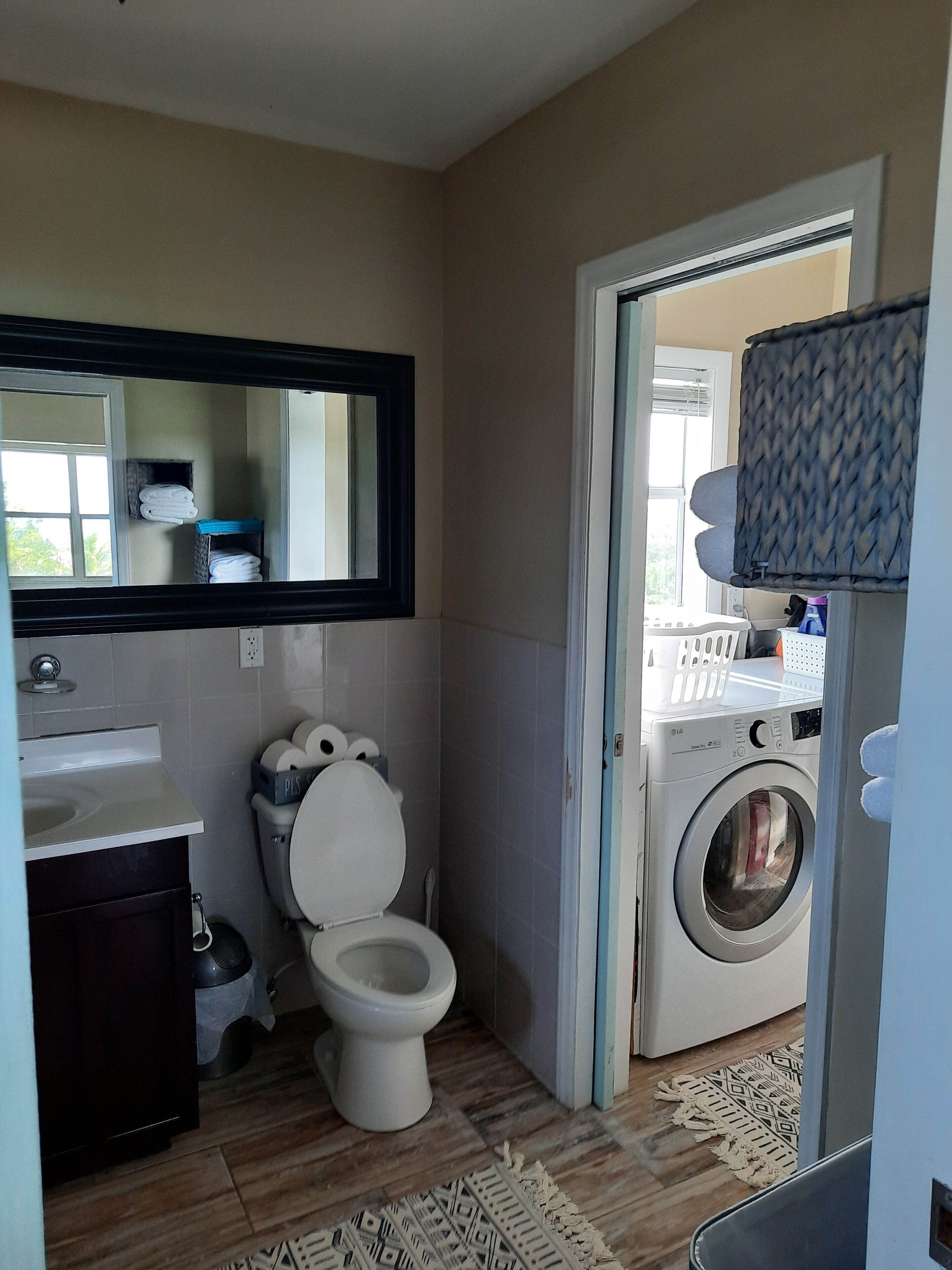 Une petite salle de bain comprenant des toilettes, un lavabo et un lave-linge.