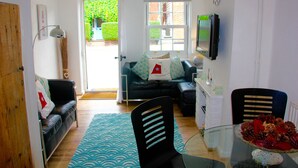 Un espacio habitable compacto con un sofá, una mesa de comedor y un televisor.