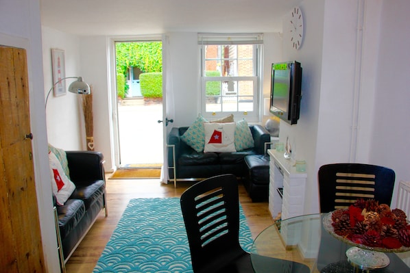 A compact living space with a sofa, a dining table, and a TV.