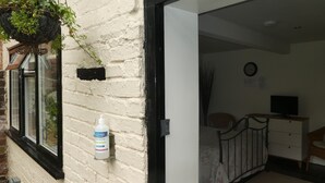 Ein Zimmer mit einem Bett, einem Nachttisch, einem Fernseher und einer Uhr an der Wand.
