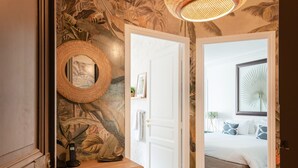 Ein Zimmer mit einem hölzernen Schminktisch, einem Spiegel und einer Pendelleuchte.