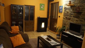 A cozy living room with a sofa, a fireplace, a television, and a bookshelf. - House of Corbelle, in Galicia, Spain. Ideal for families and pets. (Muimenta)