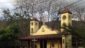 A yellow church with two towers and a bell tower, surrounded by greenery and a dirt path. - Private Ocean-View Family Villa with Pool in Islita, Costa Rica (Islita)