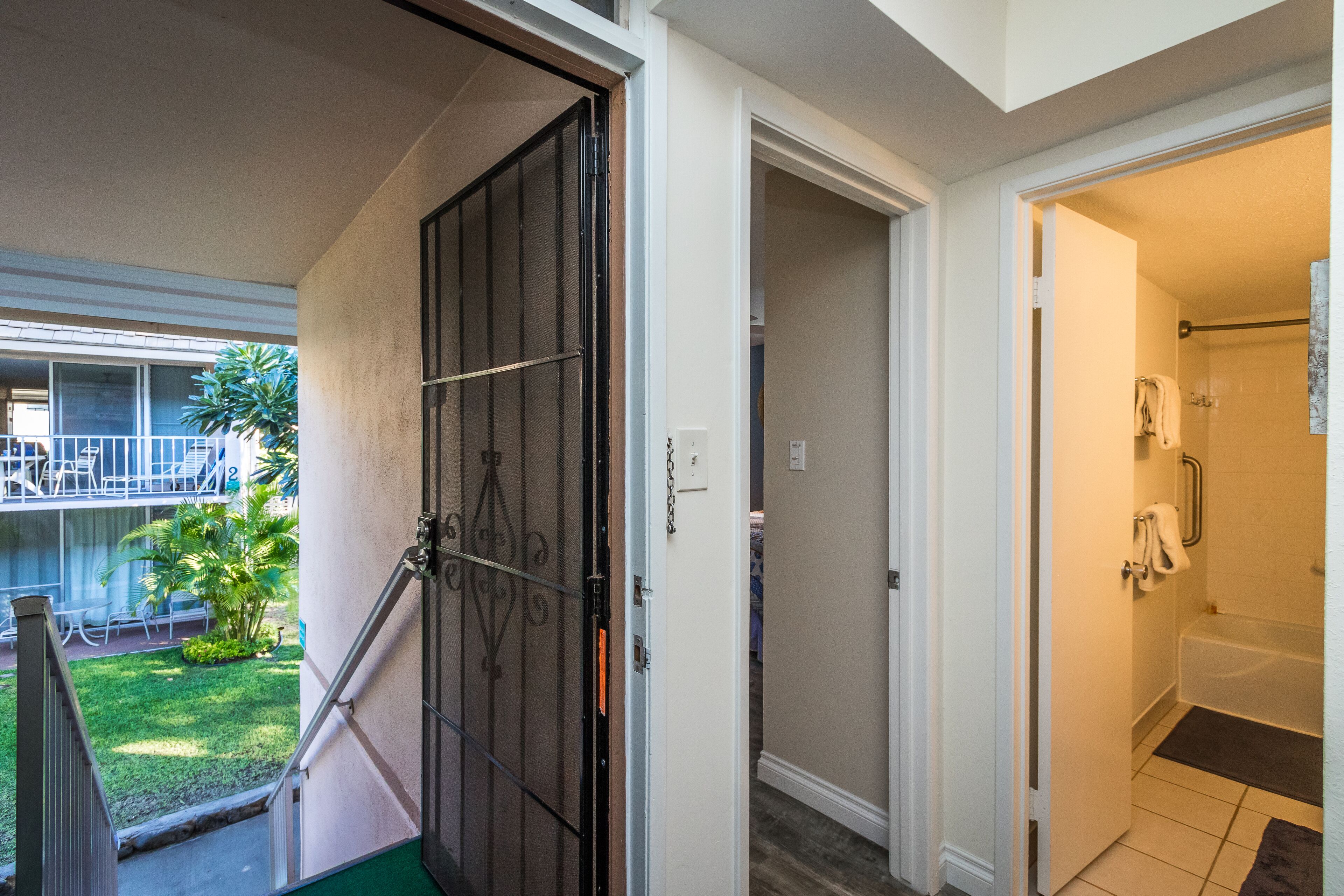Habitación de hotel con baño, una escalera que conduce a un área exterior y vistas al balcón.