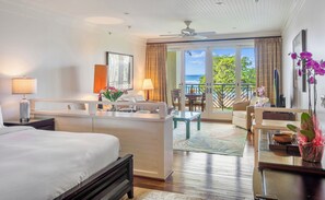 A hotel room with a bed, a desk, a chair, a dining table, and a balcony with a view of the ocean. - FALL REDUCED! Villa 202, KING bed, Amazing Ocean Views, Turtle Bay (Kahuku)