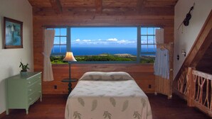 A bedroom with a large window offering a view of the ocean. - Until you experience it you don't know it exist... Exceeded Expectations (Hawi)