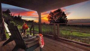 A wooden deck with a view of a sunset over a field. - Until you experience it you don't know it exist... Exceeded Expectations (Hawi)