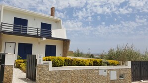A two-story building with a stone facade, a balcony, and a number 14 sign. - Villa on Beach Azul Beach (Silveira)