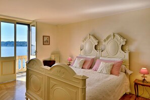 Un dormitorio con una cama grande, vistas al mar y un balcón.