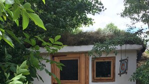Una puerta de madera rústica con un ventanal pequeño, una silla de metal y un letrero que indica 'Book House'.