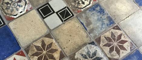 A close-up of a floor with variously colored and patterned tiles.