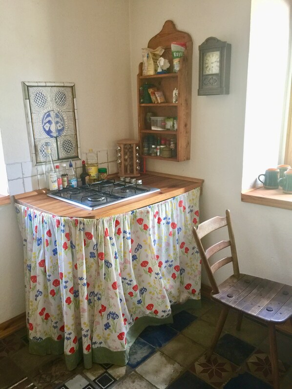 Una cocina con estufa a gas, un armario de madera y una ventana con vistas.