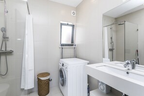 A modern bathroom with a shower, a washing machine, and a sink. - ERICEIRA HILLS- DE LUXE VILLA WITH HEATED POOL AGAINST THE ATLANTIC (Ericeira)