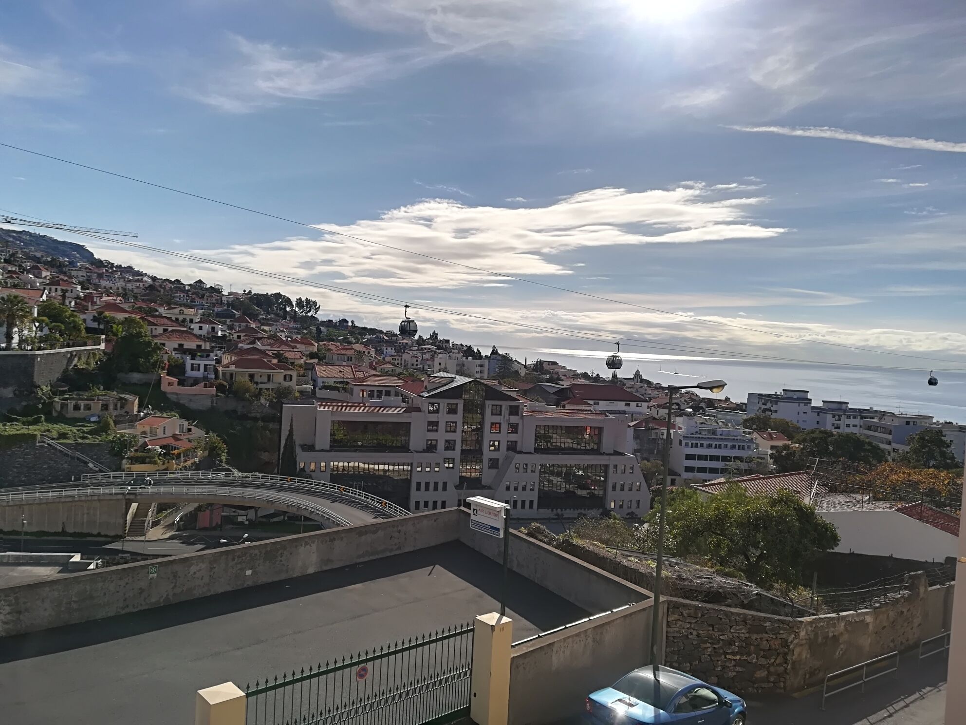 A coastal town with a cable car system, a bridge, and a mix of residential buildings.