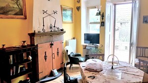 Un salon chaleureux avec une cheminée, un téléviseur et une table à manger sur laquelle est posé un gâteau.