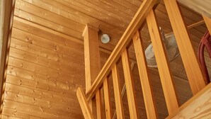 A wooden staircase with a handrail, leading to a room with a white door and a green patterned wall. - Holiday house with 3 bedrooms directly on the Useriner See with bathing beach, fireplace (Userin)
